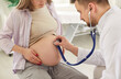© Studio Romantic - Young pregnant woman checkups visiting doctor in clinic, medical gynecologist examines fetal heartbeat, rate with stethoscope, expectant mother and prenatal health care, healthy pregnancy, testing