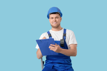 Wall Mural - male contractor writing in clipboard on blue background