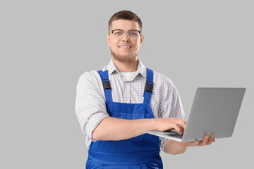 Wall Mural - male contractor using laptop on light background