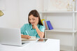 © Pixel-Shot - Little schoolgirl studying online at table in bedroom