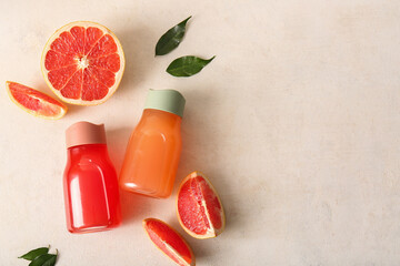 Wall Mural - Composition with bottles of tasty grapefruit juice and fresh fruits on light background