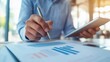 © Visual Craft - Close-up of two business professionals reviewing and signing a legal contract at a modern office desk, tablet and documents in the background
