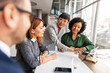 © Jelena - Diverse Team Collaborating in an Office Environment