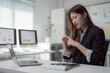 © Tj - Businesswoman experiencing wrist pain while working on a laptop in an office setting, highlighting issues related to carpal tunnel syndrome and office syndrome within health care contexts