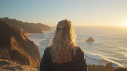 Poster - Standing on a rocky cliffside, a woman admires the endless ocean under a golden sunset while the breeze tousles her hair and waves sparkle in the fading light