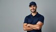 © Maryna - Smiling male service technician, delivery driver, courier stands arms crossed. Wearing navy blue polo shirt, cap. Confident look, isolated gray background. Professional work attire, worker, employee.