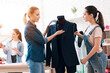 © Oleh Veres - Three girls at garment factory. One of them is measuring new dress.