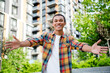 © deagreez - Portrait of nice young man arms welcome you wear shirt weekend walk downtown street outdoors