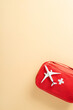 © ActionGP - Vertical red first aid kit with airplane toy, representing travel safety and emergency preparedness