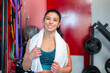 © luisrojasstock - Sporty woman smiling and holding a towel in the gym after workout