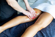 © luisrojasstock - Masseuse applying massage oil on woman's leg in spa center