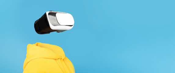Poster - A person wearing a VR headset engages with virtual reality technology. The isolated background highlights the futuristic gadget and the user's bright yellow hoodie, creating an imaginative setting.