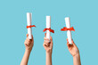 © Pixel-Shot - Female hands with diplomas on blue background