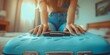 © gelas - A woman with her hands on a travel suitcase