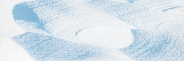Wall Mural - wide panoramic winter background with snowy ground. natural snow texture. wind sculpted patterns on 