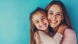© liu - Happy mother and daughter smiling and hugging against the blue background.