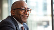 © Shahazadi - Portrait of a smiling african american man wearing glasses and a suit looking to the side