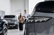 © Vladislav - A car dealer in a modern car dealership advises a customer on buying or leasing a new car. The concept of an expensive purchase or lease of a modern car.