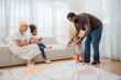 © Hip.hub - Family enjoying quality time at home while encouraging toddler's first steps during the afternoon