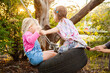 © Austockphoto - Two little girls on tyre swing in backyard