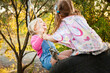 © Austockphoto - Blond and brunette little girls laughing on swing together