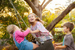 © Austockphoto - Two little girls on tyre swing in backyard