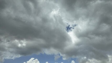 Wall Mural - ominous grey clouds moving over patches of blue sky, cape town, south africa.