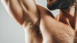 © Favio - Muscular man's armpit with natural body hair and toned skin illuminated by soft light.
