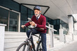 © Jelena - Senior Businessman on Bicycle Using Smart Phone Outside Office