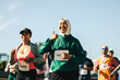 © Jacob Lund - Two women running a race with joyful expressions and thumbs up