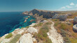 © budi - Beautiful ocean meets rocky coast with steep cliffs and clear turquoise waters under a serene blue sky on a bright sunn