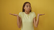 © Krakenimages.com - Young woman shrugging on yellow background isolated showing confusion or indifference