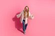 © deagreez - Stylish young woman in pink fur coat expressing excitement against a trendy pink backdrop