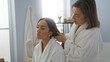 © Krakenimages.com - Woman and daughter bonding at spa wearing robes in a serene indoor wellness center.