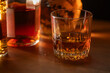 © Tetra Images - Glasses of whiskey on wooden table