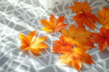 Poster - Vibrant autumn leaves scattered on a patterned tablecloth in warm sunlight