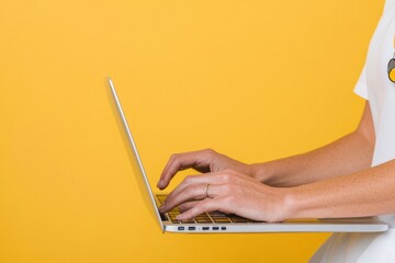 Aufkleber - Minimalist Digital Workspace Vibrant Yellow Backdrop Reveals Sleek Laptop Interaction - Productivity, Creativity, and Modern Professional Ergonomics