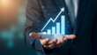 © GG Kenji - Hand Analyzing Holographic 2026 Business Goals Interface with Market Growth Graphs & Investment Strategies