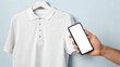 © saokaew - A man's hand holding a blank white polo shirt with a blank screen ready for displaying logos in a studio setting