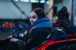 © qunica.com - Two young friends ride together in a bumper car at a fairground, enjoying lively moments and the joy of spending time together, creating memories and having fun during the winter holiday season.