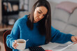 © Ljustina - Woman drinking coffee and managing home finances with calculator and documents