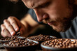© Ann - Man examines different coffee beans in bowls during a tasting session at a local café in the afternoon