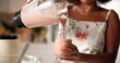 © peopleimages.com - Hands, woman and pour smoothie in home with nutrition drink, detox benefits and weight loss. African, person and glass with organic beverage for natural diet, morning protein and digestion wellness