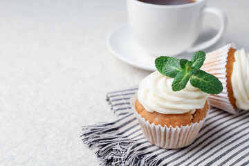 Wall Mural - delicious carrot cupcakes with mint on light textured table, closeup. space for text