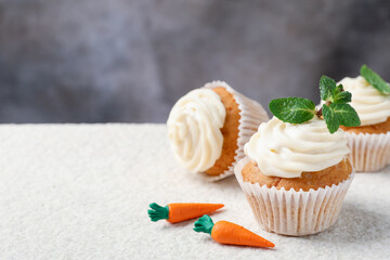 Wall Mural - delicious carrot cupcakes with mint on light textured table, closeup. space for text