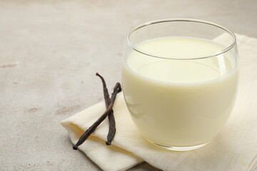 Wall Mural - glass of milk and vanilla pods on light grey table, closeup