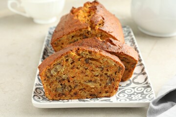 Wall Mural - cut homemade carrot cake with nuts on light grey table, closeup
