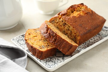 Wall Mural - cut homemade carrot cake with nuts on light grey table, closeup