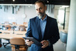 © Marko Geber - Portrait of a confident businessman with tablet standing in modern office