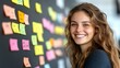 © Bagong - Smiling woman near sticky notes on a wall.